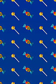 Top view of pattern of whole sweet crystal candies and lollipops arranged on blue background