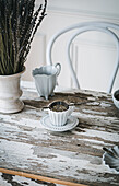 White ceramic cup of aromatic tea with fresh lavender flowers placed on wooden table
