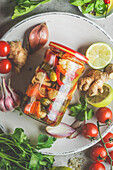 Top view of Close up of preserve jar with various pickled vegetables on plate with ingredients