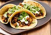 Appetizing Mexican tacos with spicy chili peppers and cilantro on plate. Generative AI