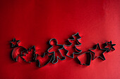 Top view of set of various cookie cutters located on red surface as symbol for Christmas holiday