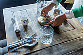 A cropped unrecognizable persons enjoys a beautifully presented gourmet dish at a Michelin star restaurant in Zermatt, Switzerland, showcasing fusion cuisine with a focus on local and seasonal products.