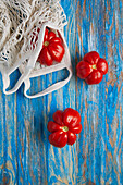Top view of fresh ripe red tomatoes with eco friendly cotton mesh bag placed on blue stripped wooden table