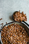 Bowl with raw oragnic flax seeds on concrete table