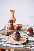 Delicious sweet chocolate mousse desserts in glass jars with silverware on wooden table against white background