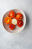 Top view of Interior decoration with bowl full of Ranunculus flower head on concrete table