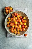 Bowl with organic ripe white sweet cherries on the concrete kitchen table