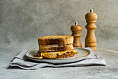 Slices of fried bread with egg coating on ceramic plate next to cloth napkin on concrete background