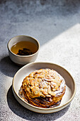 High angle of sweet almond pastry with cup of green tea against gray background in sunlight