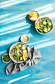 From above of healthy vegetables salads with organic cucumber, red onion, coriander and chopped nuts placed in a blue concrete table