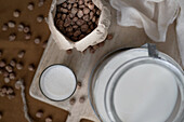 Top view of home made organic horchata drink served in transparent glasses on wooden table near almonds in a rustic kitchen