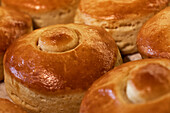 Nahaufnahme von frisch gebackenem, leckerem, heißem, rundem Brot mit knuspriger Kruste auf einem Tisch in einer Bäckerei