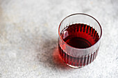 High angle of traditional saperavi Georgian red wine in transparent glass served in clean concrete gray background table