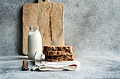 Rye fresh bread and homemade almond milk in vintage glass bottle on the stone kitchen table