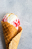 From above waffle cones with cherry ice cream on concrete background