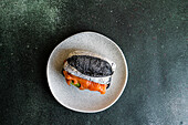 Healthy snack with sour dough and activated carbon bun and salmon fish in sandwich