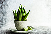 Bowls of bamia vegetable on concrete background