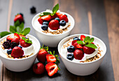 Appetitliches süßes Dessert mit frischen Erdbeeren und Blaubeeren, serviert auf Joghurt mit Müsli in einer Schale