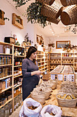 Side view of pregnant female with brown hair in purple dress standing and choosing products in eco friendly shop