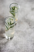 Glassses of rosemary vodka served on concrete table