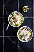 Healthy vegetable salad with raw and organic ingredients served in the bowl on grey concrete table