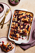 Top view of appetizing homemade Italian cake with fresh berries placed near golden cutlery on marble table