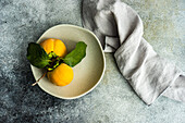 From above autumnal place setting with fresh ripe persimmon fruits on concrete table