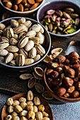 From above bowls with different kinds of nuts on concrete table background