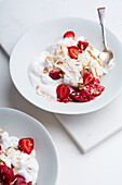 Eton's mess summer dessert with berries, crushed meringue and whipped cream