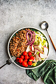 From above bowl with buckwheat and vegetables served on concrete grey table