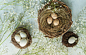 Top view of easter holiday card with nest and eggs on concrete background