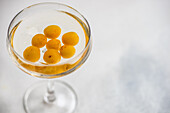 Glas mit Kirsch-Wodka-Cocktail und Beeren auf dem Tisch