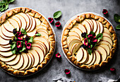 Top view of delicious homemade galette cakes decorated with apple slices placed on plates