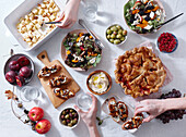 Vegetarian dinner with various snacks and dishes: salad plates, bruschetta, roasted vegetables and a pie