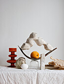 Arrangement with handmade sculpture and a peach