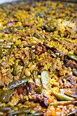 Close-up of delicious traditional Spanish paella with chicken and beans in garden