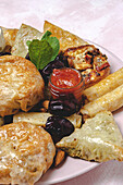 Blick von oben auf verschiedene leckere arabische Speisen mit Salsa und frischen Minzblättern in der Nähe von Mandeln während des Ramadan-Festes