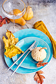 Autumnal place setting with blue ceramic dinnerware and seasonal decoration on concrete table