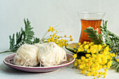 Türkischer Genuss und Tee auf dem Tisch mit gelben Mimosenblüten