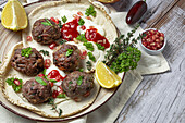 Traditionelle hausgemachte Rind- und Lammfleischbällchen mit arabischem Brot, Tomatensauce, Granatapfel und Kräutern. Halal-Essen