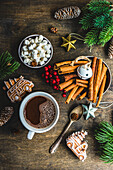 From above mug with hot chocolate and mini marshmallows with spices on background with christmas decorations