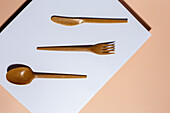 Overhead view of brown eco friendly cutlery on pastel background