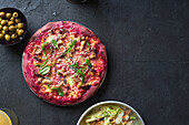 Purple colored rustic pizza with beetroot and vegetarian topping. Top view healthy food recipe