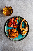 top view of Salmon steak with spicy carrot and cherry tomatoes served with a glass of dry white wine over concrete