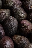 Top view full frame of whole ripe brown avocados placed together as background