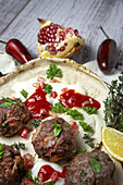 Traditionelle hausgemachte Rind- und Lammfleischbällchen mit arabischem Brot, Tomatensauce, Granatapfel und Kräutern. Halal-Essen