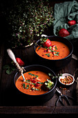 From above composition with delicious homemade tomato and strawberry Gazpacho soup served in bowls on rustic wooden table
