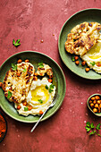 Top view of delicious roasted cauliflower with mashed potatoes and spiced harissa chickpeas served on ceramic plate on red table background