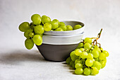 Stoneware with ripe green grape on concrete background