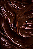 Hintergrund von oben mit verführerischer brauner Schokoladenpaste zum Bestreichen von Brot